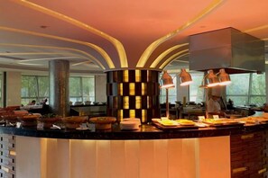 A modern kitchen with a central island, pendant lighting, and a view of the dining area. - Shanghai Changxing International Hotel (Shanghai)