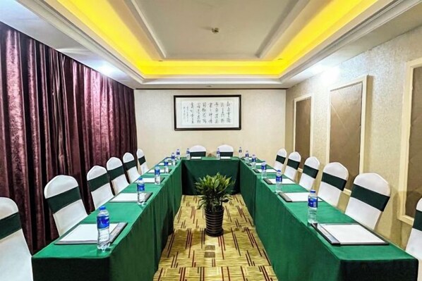 A conference room with a long table, chairs, water bottles, and a potted plant. - Shanghai Changxing International Hotel (Shanghai)
