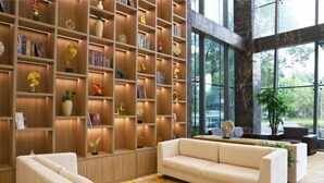 A modern living room with a large bookshelf, a sofa, and a coffee table. - Shanghai Changxing International Hotel (Shanghai)