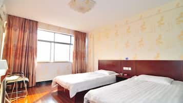 Una habitación de hotel con dos camas, un escritorio y una ventana con cortinas.