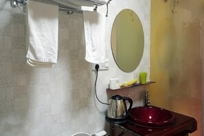 A bathroom with a sink, mirror, towel rack, and a green cup on a shelf. - Jiancheng Hotel (Ningbo)
