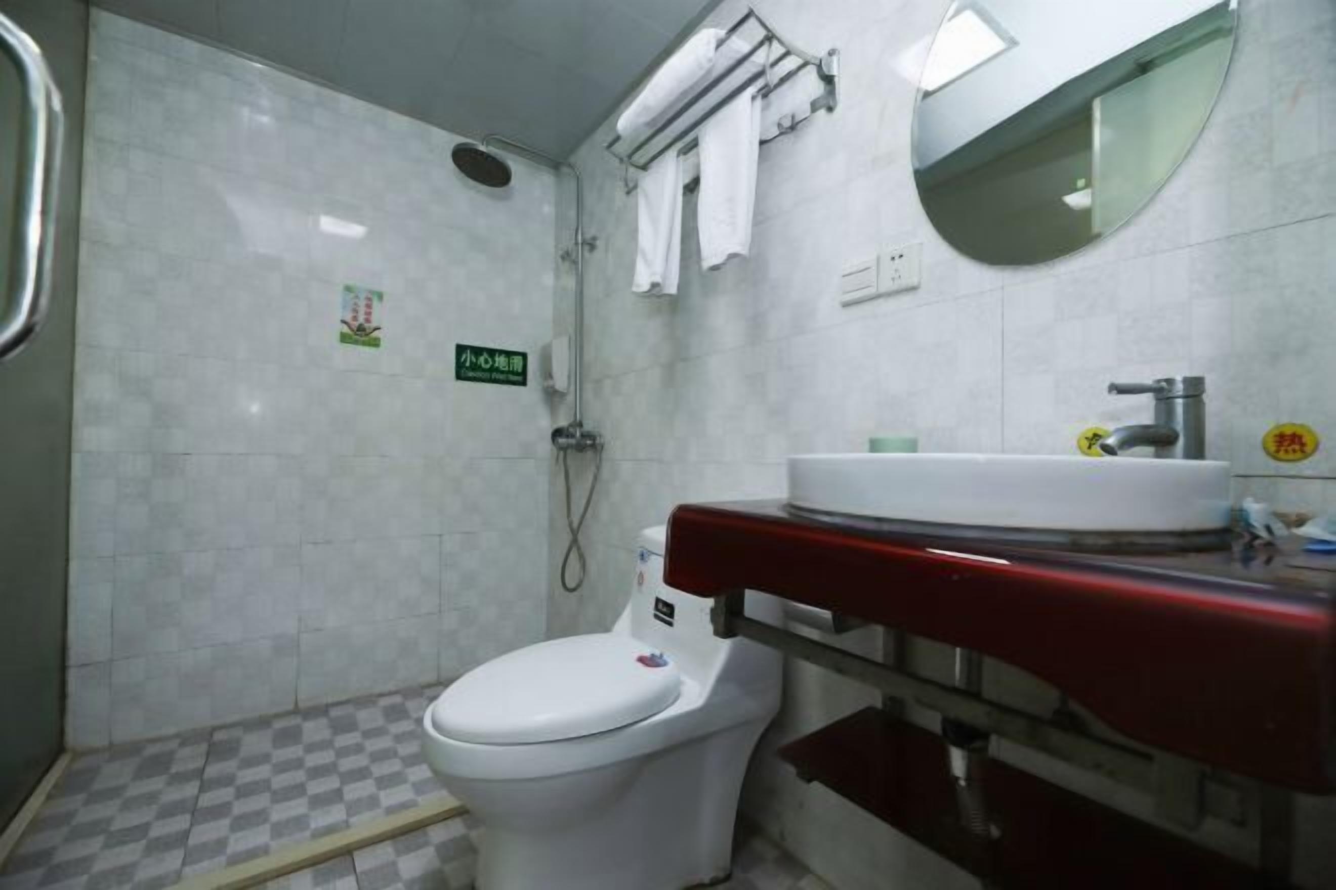 Un baño con inodoro, lavabo, espejo y ducha.