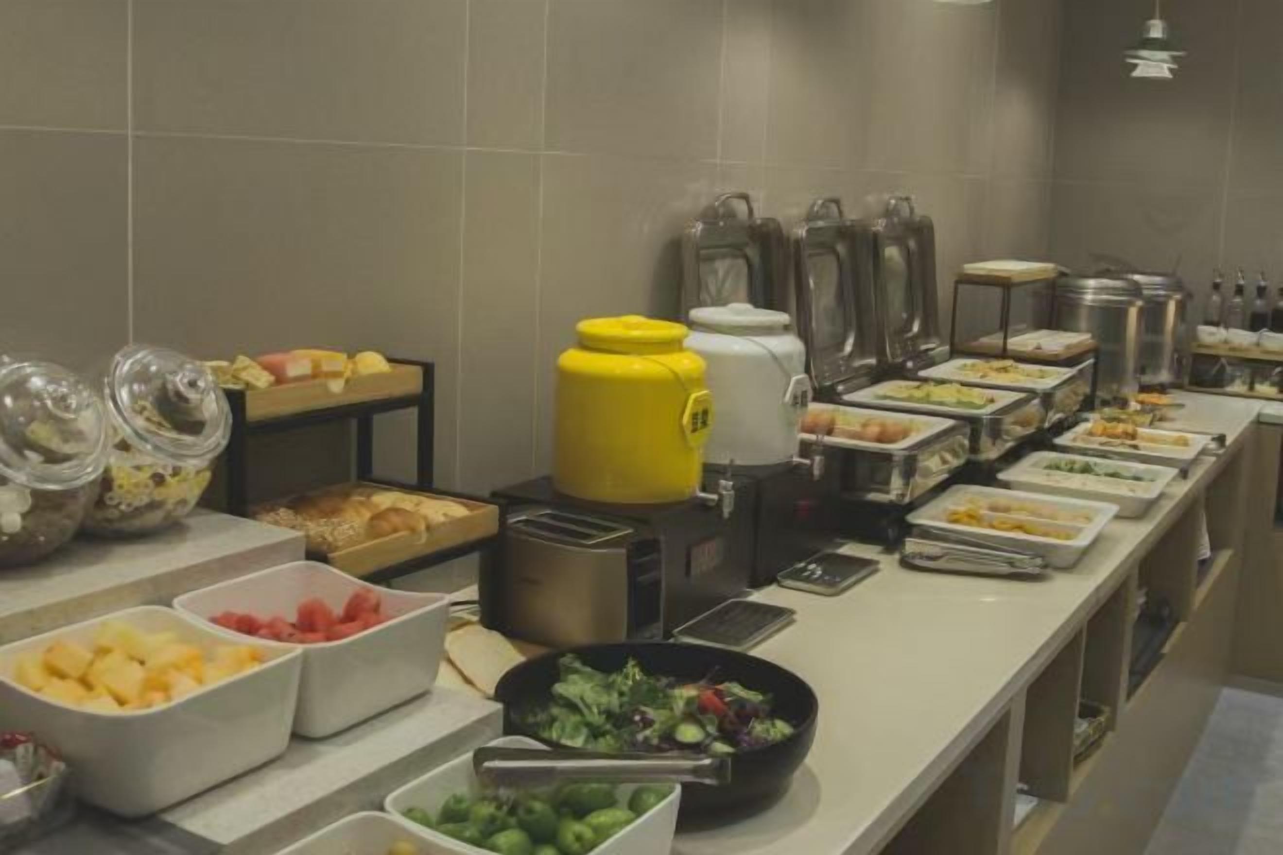 A buffet setup with various food containers and kitchen appliances.