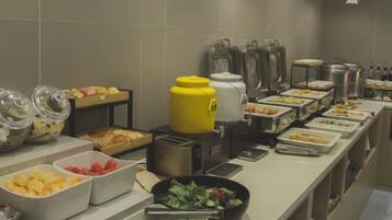 A buffet setup with various food containers and kitchen appliances.