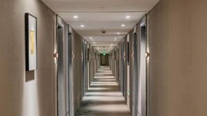 Un long couloir étroit, avec des portes des deux côtés, qui mène à des pièces individuelles.