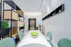 A modern conference room with a long table, chairs, and a bookshelf. - Homeinn Selected Hotel (Lishui High-Speed Railway Station Wanda Plaza) (Lishui)