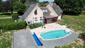 A residential property with a swimming pool, a covered patio, and a landscaped yard. - Grande Maison à la Campagne aux Portes du Morvan (Fours)