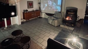 A cozy living room with a fireplace, a television, and a comfortable seating area. - Grande Maison à la Campagne aux Portes du Morvan (Fours)