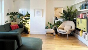 Un salon moderne avec un canapé, un fauteuil et une bibliothèque.