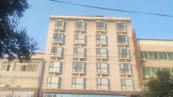 A multi-story building with a flat facade, multiple windows, and a visible storefront at the ground level.