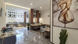 A modern hotel lobby with a marble floor, a reception desk, and a dining area with tables and chairs. - Tung Pak King Hyatt Delicate Hotel (Tongbai)