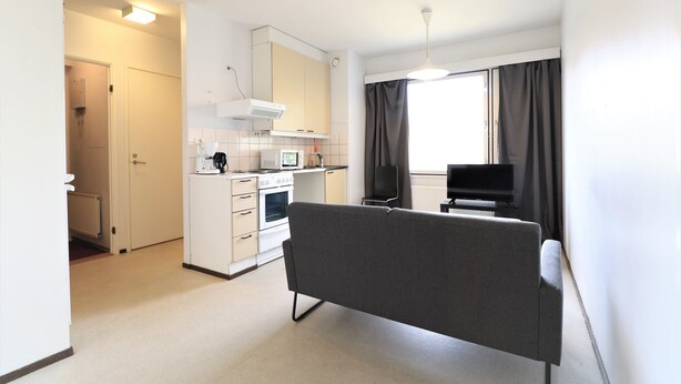 A compact living space with a kitchenette, a sofa, and a television. - Forenom Serviced Apartments Porvoo (Porvoo)