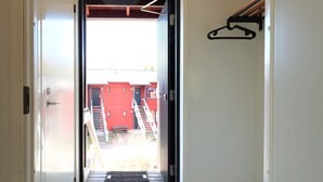 A hallway with a door leading to a staircase and a red building in the background. - Forenom Serviced Apartments Porvoo (Porvoo)