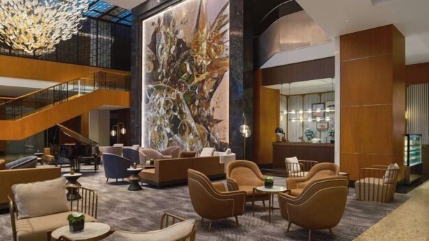 A spacious lobby with a modern staircase, comfortable seating areas, and a large abstract mural. - Grand Madison Kunshan Huaqiao (Kunshan)