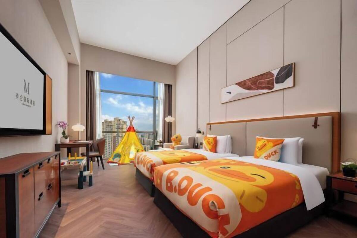 Ein Hotelzimmer mit einem großen Bett, einem Schreibtisch, einem Stuhl, einem Fenster und einem Zelt.