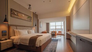 Une chambre d’hôtel moderne dotée d’un grand lit, d’un bureau, d’une chaise et offrant une vue sur la ville.
