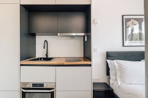 A compact kitchenette with a stainless steel oven, a sink, and a microwave. - The Antigallican by Nestor (London)