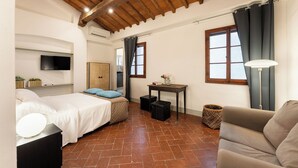Quarto com cama, escrivaninha, cadeira e sofá.
