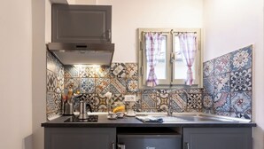 Uma cozinha compacta com design moderno, com fogão embutido, pia e geladeira.