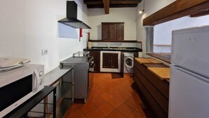 Eine kompakte Küche mit Mikrowelle, Herd, Backofen und Waschmaschine.