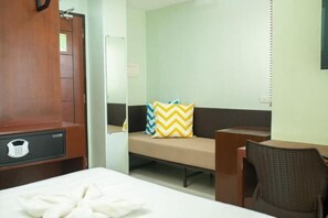 Una habitación de hotel con cama, sofá, escritorio y silla.