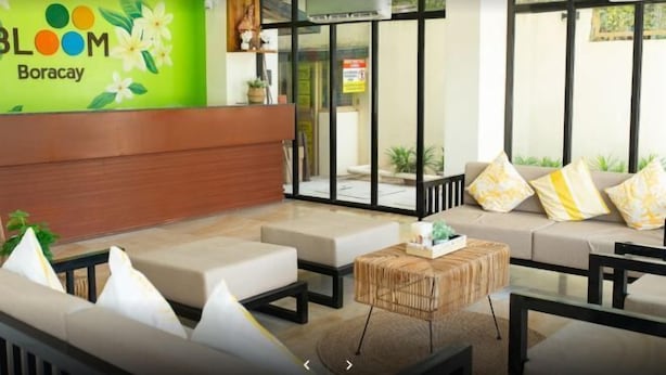 A modern hotel lobby with a reception desk, seating area, and large windows. - Bloom Boracay (Boracay Island)