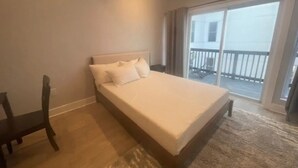 Une chambre avec un lit, une chaise et une vue sur le balcon extérieur.