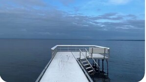 A pier extending into calm water with a clear sky above. - Enjoy views of beautiful Houghton Lake in charming LARGE home that sleeps 10.  (Houghton Lake)