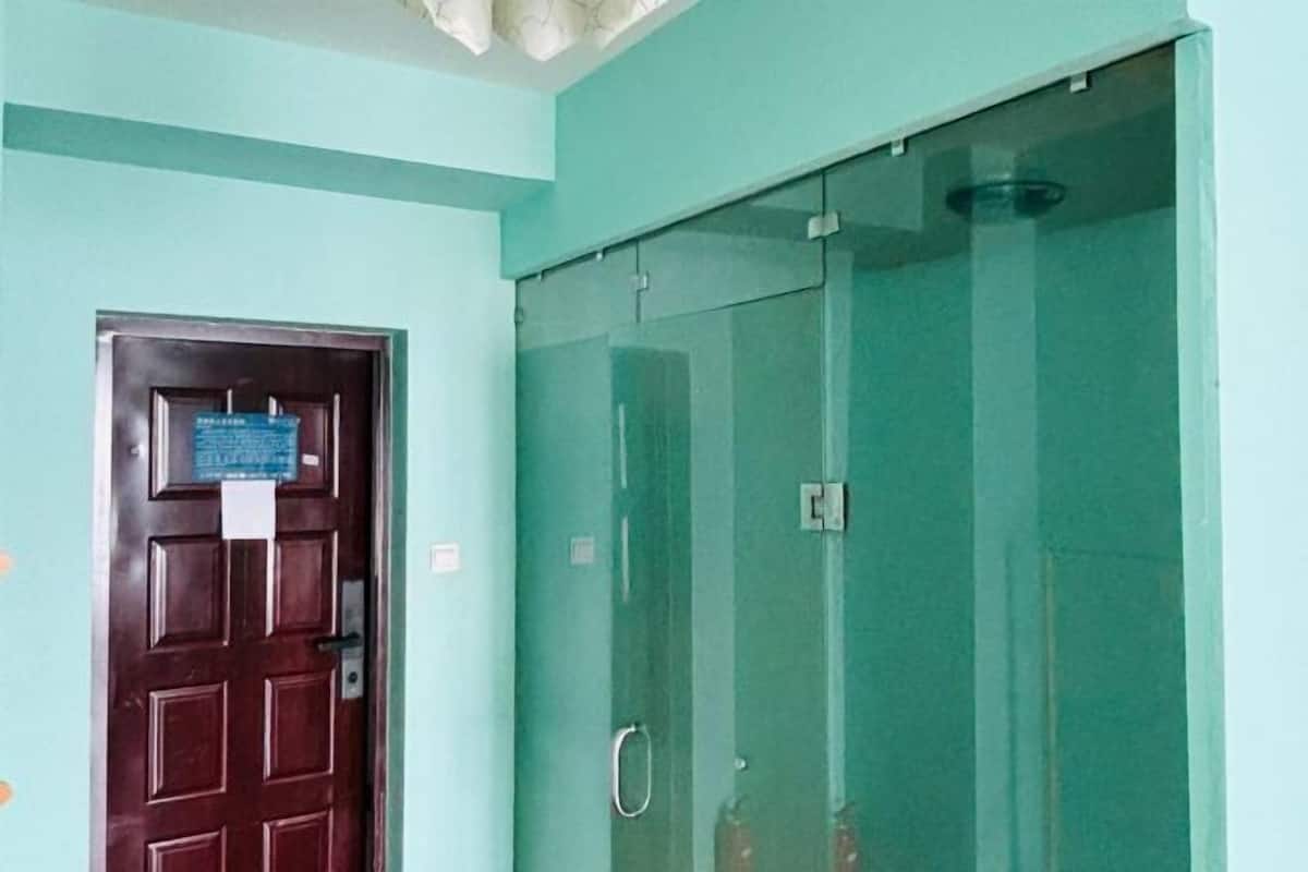 Una habitación con puerta de madera y separador de vidrio.