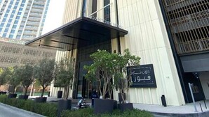 Un immeuble moderne et imposant, doté d’une entrée remarquable et d’une enseigne en arabe.