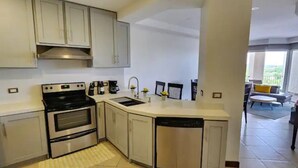 A modern kitchen with white cabinets, a built-in oven, and a dishwasher. - Serenity Oasis in Playa Langosta (Playa Langosta)