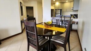 A dining area with a round table, four chairs, and a fruit bowl on the table. - Serenity Oasis in Playa Langosta (Playa Langosta)
