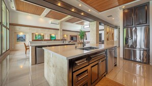 A spacious kitchen with a large island, stainless steel appliances, and a wooden ceiling. - Private Luxurious Beachfront Villa with Chef, Household Staff, Concierge  (Potrero)