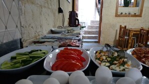 A buffet with various dishes including sliced cucumbers, tomatoes, and a salad. - Ruken Hanım Konağı (Gaziantep)