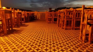 A corridor with wooden chairs and a patterned floor, leading to a building entrance. - Ruken Hanım Konağı (Gaziantep)