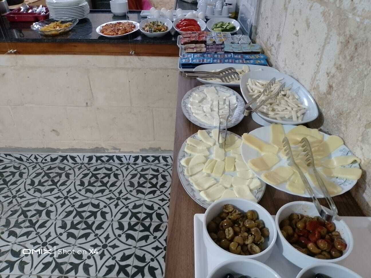 A buffet table with various food items and utensils.
