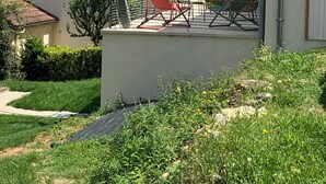 A house with a tiled roof, a covered patio with outdoor furniture, and a garden area. - Gite Indépendant 4-6 Personnes Avec Piscine Privative (Gourdon)