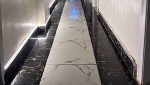 A hallway with a marble floor, white walls, and a ceiling fan. - Future Hostel (Cairo)