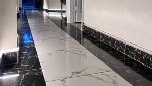A hallway with a marble floor, a chair, and a door. - Future Hostel (Cairo)