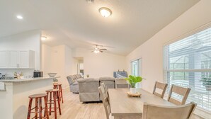 A modern kitchen with a dining area, a large window with blinds, and a ceiling fan. - Near State Parks! Crystal River Home w/ Hot Tub (Crystal River)