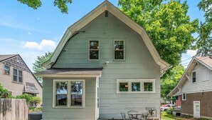 A two-story house with a gable roof, a front porch with a table and chairs, and a red fire hydrant in the yard. - Heron House - Elevated Vintage Downtown Victoria (Victoria)
