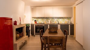 A compact kitchen with a dining table, cabinets, and a tiled backsplash. - Casa Mameli by Wonderful Italy (Conversano)