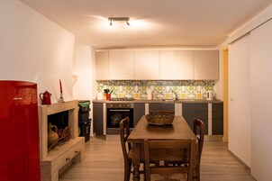 Cocina compacta con mesa, armarios y salpicadero de azulejos.
