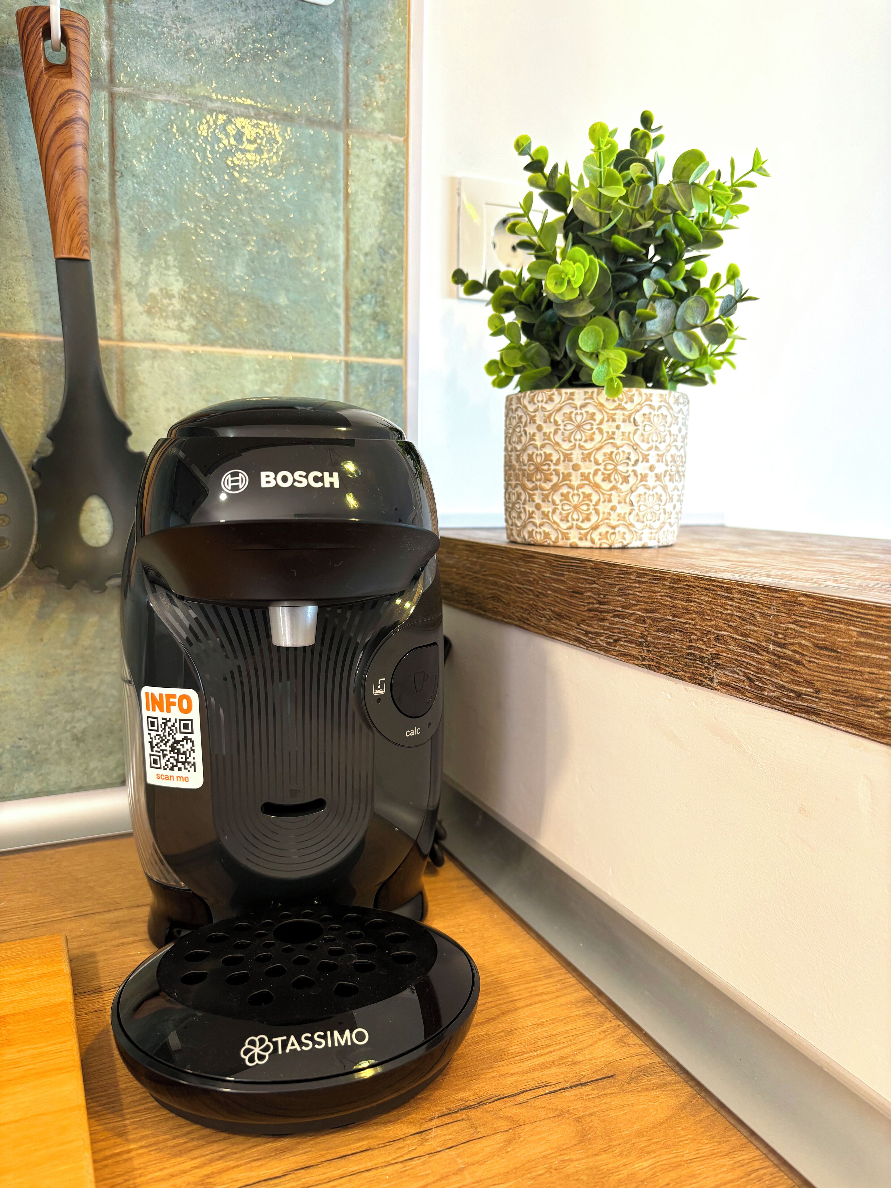 Kahvinkeitin, jonka yläosassa on QR-koodi ja tuotemerkki »BOSCH» ja pohjassa »TASSIMO».