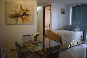Departamento Deluxe, varias camas, tina, vista al jardín | Área de sala de estar | Televisión LED de 42 pulgadas con canales por cable