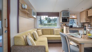 A compact living space with a sofa, a dining table, and a kitchen area.