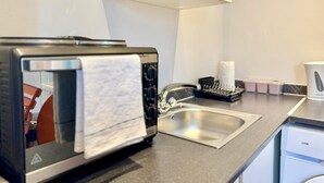 Una kitchenette con tostadora, pileta y cafetera.