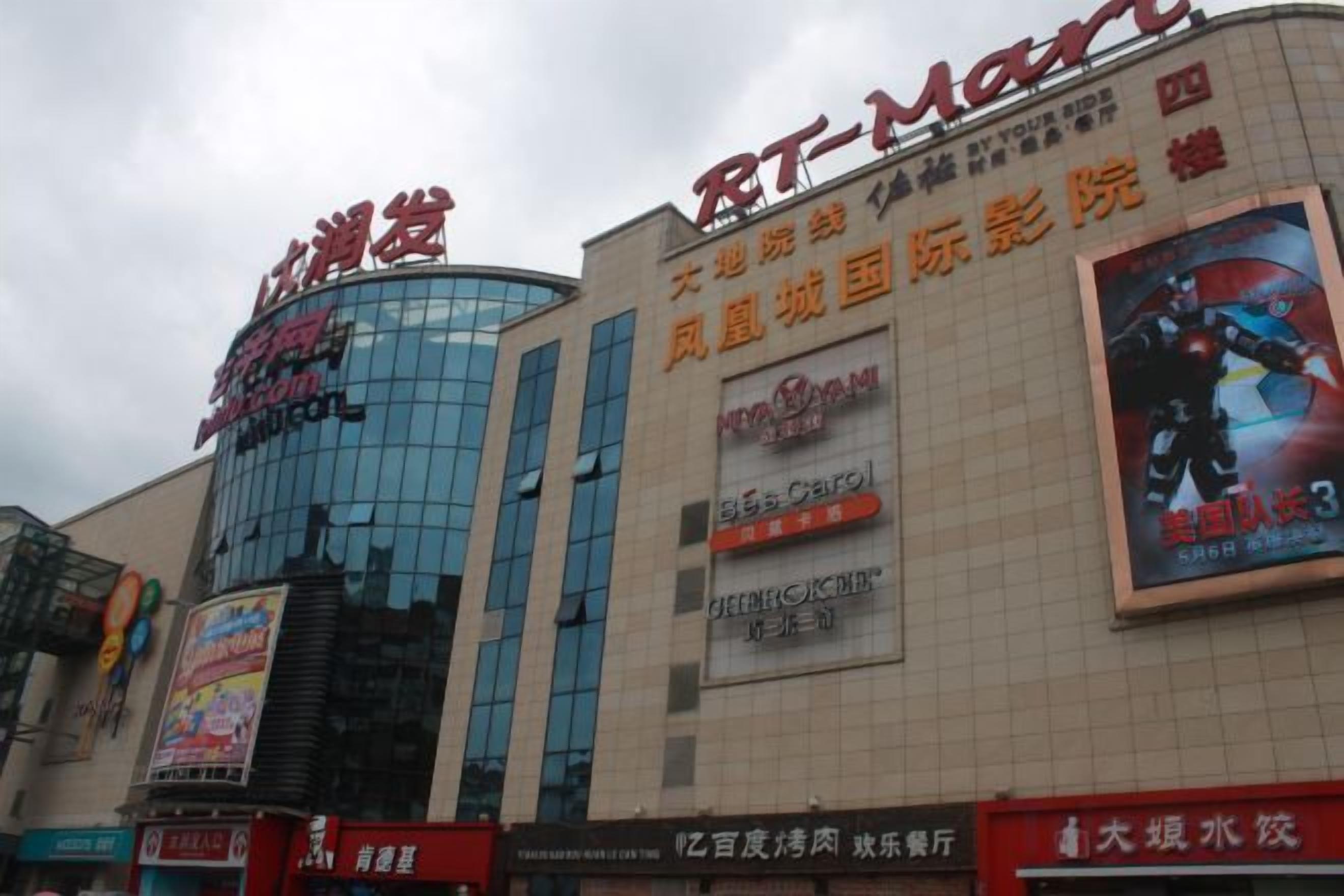 Un edificio comercial con varios letreros, incluyendo un gran anuncio de una película.