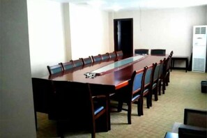 A conference room with a long table and chairs, a door, and a whiteboard.