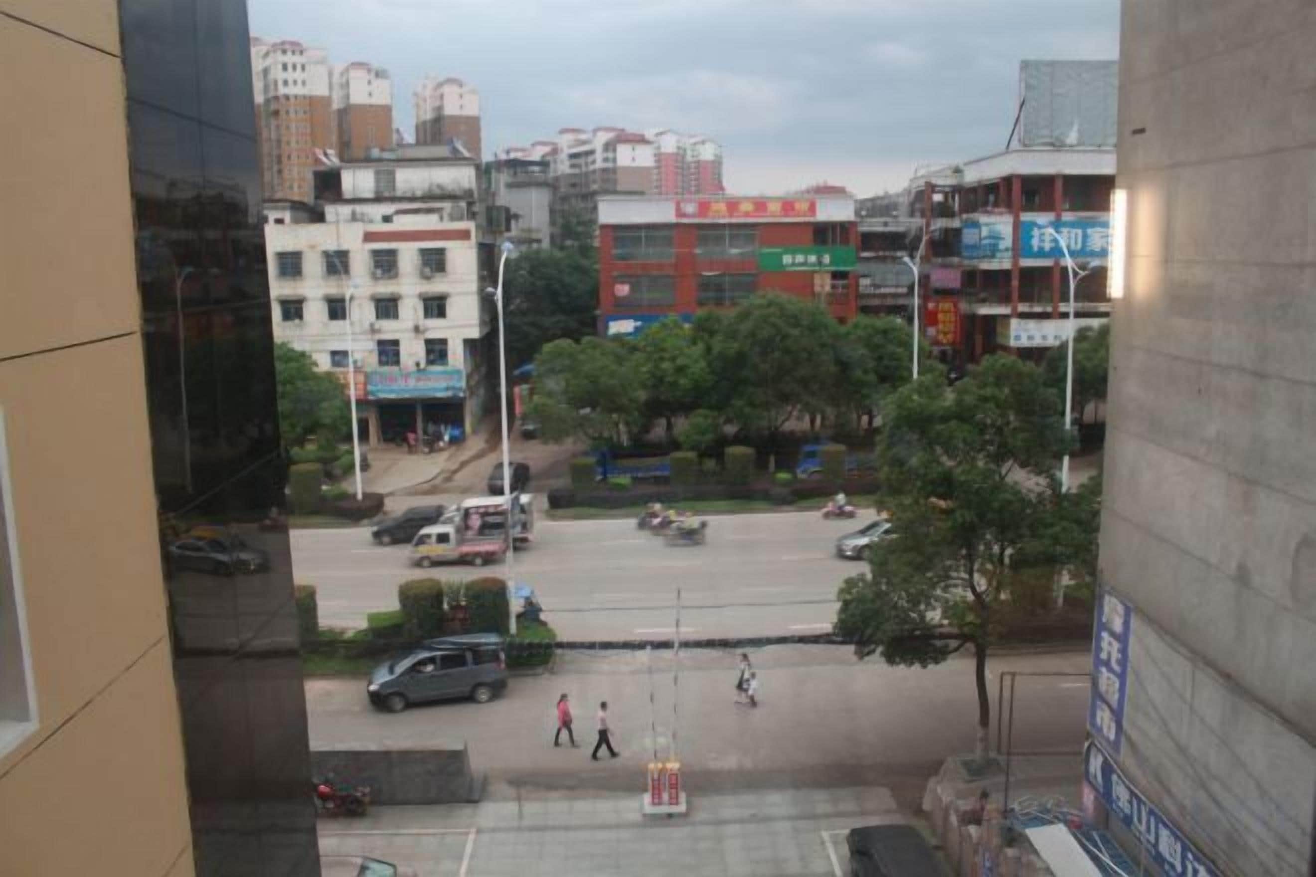 A city intersection with buildings, vehicles, and pedestrians.